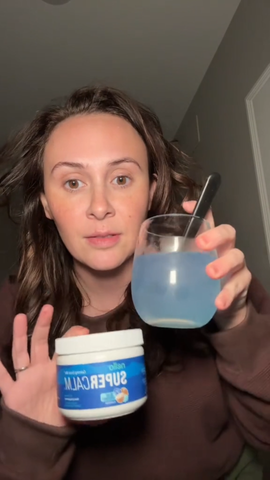 Man drinking a pink Tavo LiquidCalm liquid calm drink from a reusable bottle as part of his evening wind-down routine.
